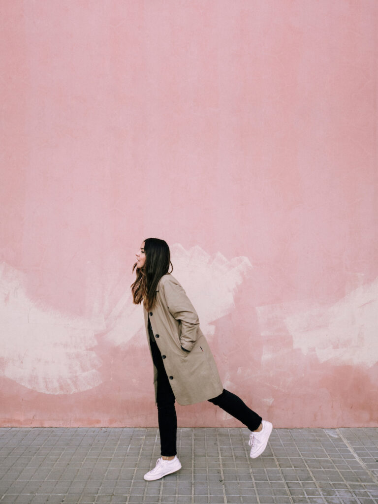 Carol Peña caminando frente a fondo rosado, Foto de creadora de contenido atípica y exitosa - Carol Peña